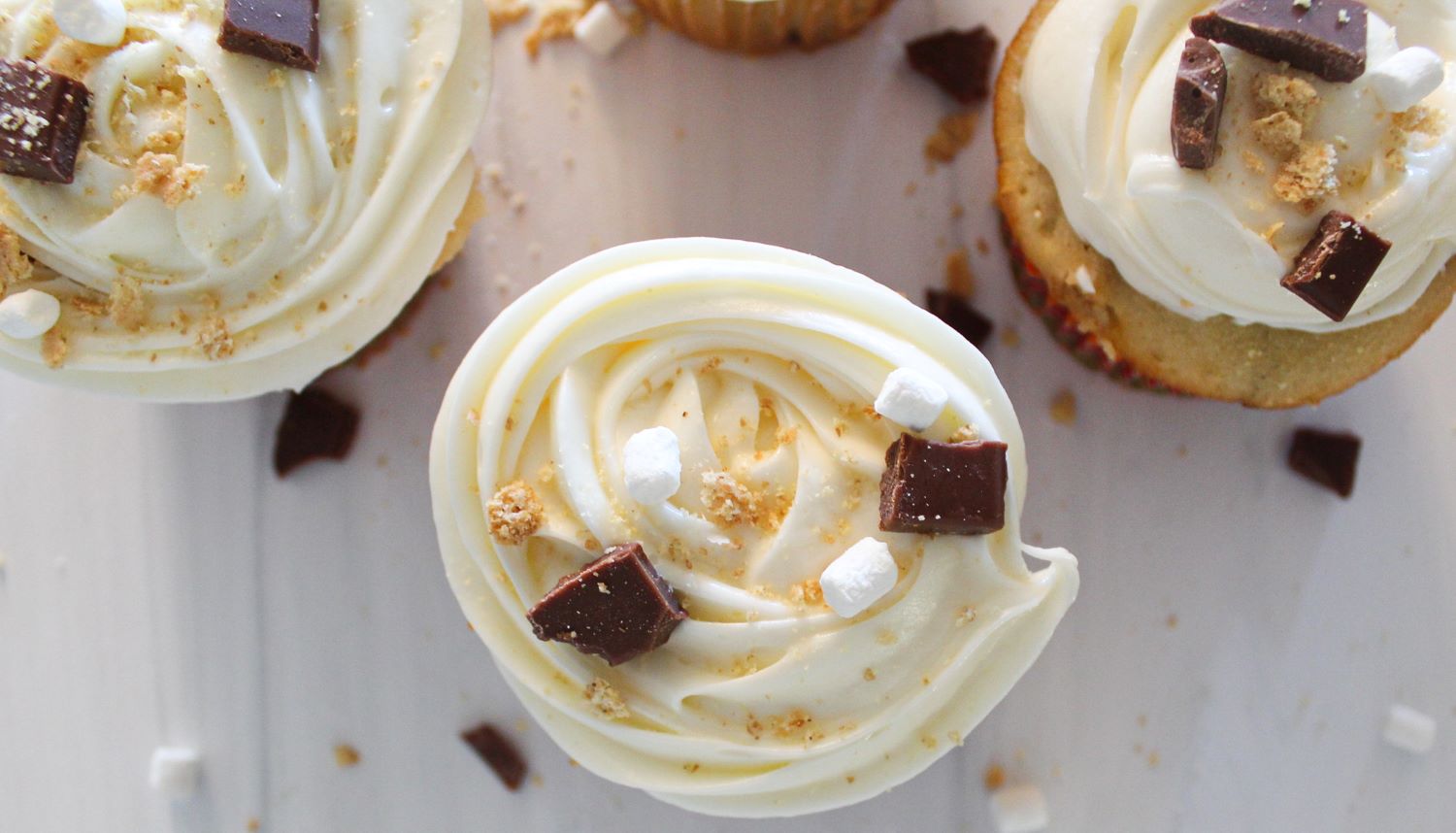 four s'mores cupcakes with marshmallow frosting