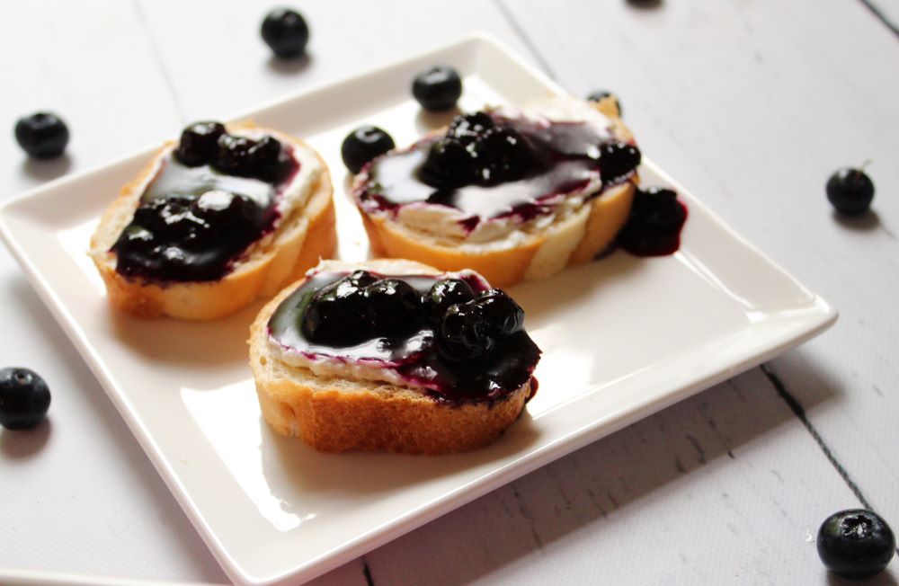 angled view of blueberry goat cheese dip on baguette