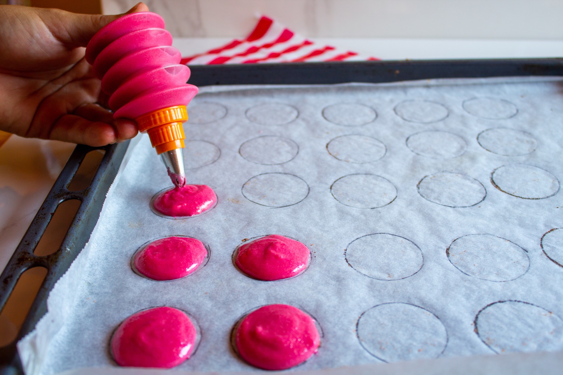 squeeze macaron cookie dough onto the cookie sheet