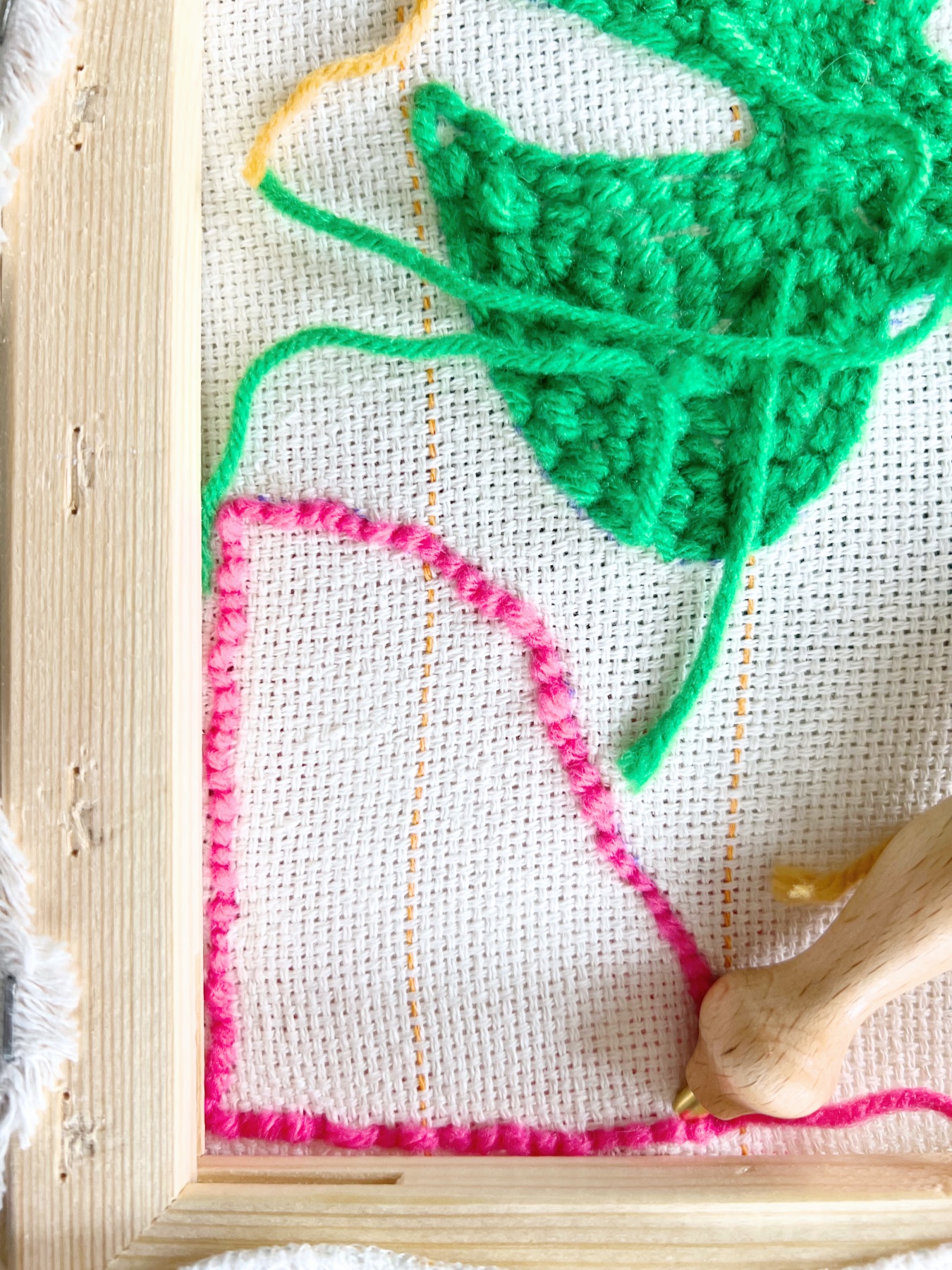punching the rug with pink yarn
